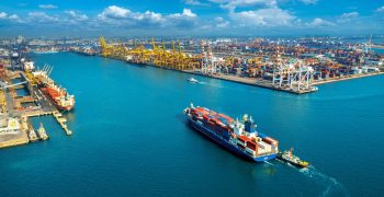 Aerial view of cargo ship and cargo container in harbor.