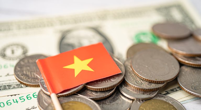 Stack of coins with Vietnam flag on white background.