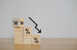 financial-crisis-concept-wooden-block-signs-symbols-shopping-cart-white-background-with-percentage-sign-store-loss-income-capital-lost-cost-reduction-declining-chart-down-profit
