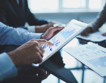Image of businessperson pointing at document in touchpad at meeting
