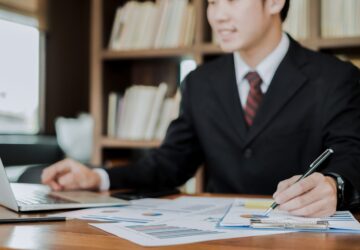 young businessman working with mobile laptop and documents in office, business concept