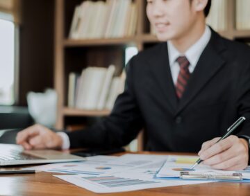 young businessman working with mobile laptop and documents in office, business concept