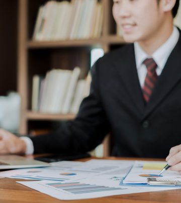 young businessman working with mobile laptop and documents in office, business concept